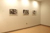 Three black and white photos displayed in an otherwise empty room.