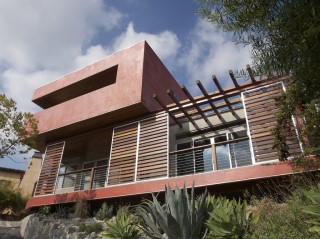 A view of the outside of a house, with movable panels partly shading the house's deck. A view of the outside of a house, with movable panels partly shading the house's deck.