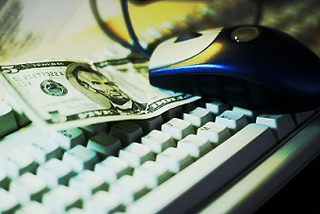 Five dollar bill on a computer keyboard. Five dollar bill on a computer keyboard.