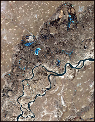 A satellite photograph of a meandering river. A satellite photograph of a meandering river.