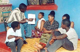 Several people sitting and listening to a counselor. Several people sitting and listening to a counselor.