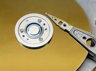A photograph of a platter and actuator arm from a computer hard drive. A photograph of a platter and actuator arm from a computer hard drive.