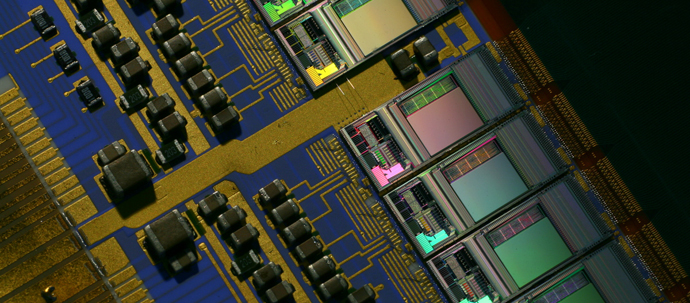 A close-up photo of a blue circuit board, mostly covered with multi-colored elements. A close-up photo of a blue circuit board, mostly covered with multi-colored elements.