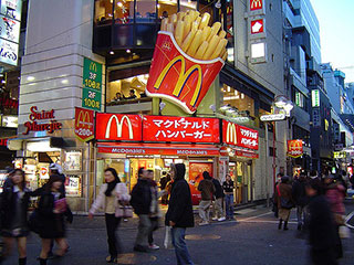 A photo of a McDonald's in Tokyo, Japan with passersby in the foreground. A photo of a McDonald's in Tokyo, Japan with passersby in the foreground.