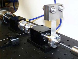 Springs and masses are connected via a shaft sitting on a metal surface. Springs and masses are connected via a shaft sitting on a metal surface.