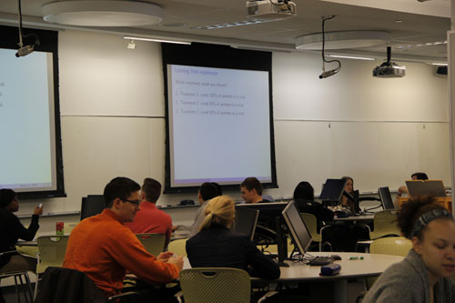 <p>We aimed to have a few concept questions in each class. For these, we showed a slide with a multiple choice question, typically related to content just discussed in a brief lecture segment. The students responded to concept questions by logging their answers via handheld clickers they brought to class.</p> <p>Participating in clicker questions was worth 5% of students’ grades; answers were not graded for correctness. This also served as an incentive for students to attend class.</p> A multiple-choice question is shown on a projector screen. Students use handheld clickers to submit their answers.