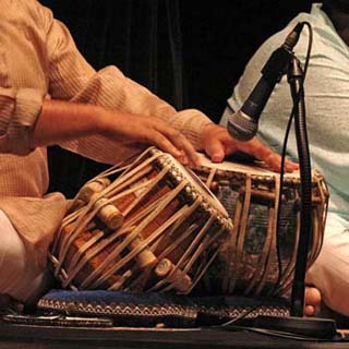 Closeup photo of performance on the tabla, a pair of small single-headed hand drums. Closeup photo of performance on the tabla, a pair of small single-headed hand drums.