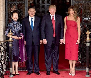 Two smiling, suit-wearing gentlemen are flanked by two elegantly-dressed attractive women. Two smiling, suit-wearing gentlemen are flanked by two elegantly-dressed attractive women.