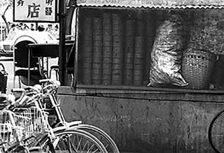 A photograph of coal briquettes stacked against a restaurant in Beijing, China. A photograph of coal briquettes stacked against a restaurant in Beijing, China.