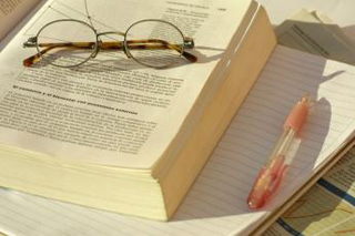 A photo of glass sitting on top of an open book. A photo of glass sitting on top of an open book.