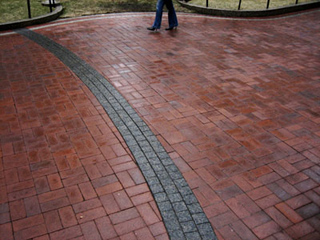 Photo of feet along a brick-paved path. Photo of feet along a brick-paved path.