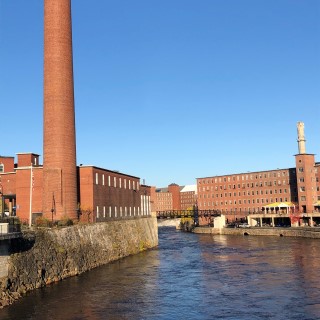 A river flanked by large brick buildings. A river flanked by large brick buildings.