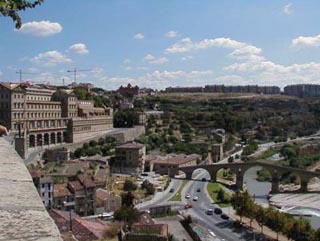 Photo of a city overlooking a highway and a river. Photo of a city overlooking a highway and a river.