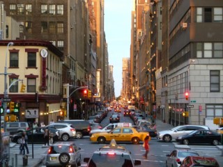 A city intersection with stoplights, automotive traffic, and pedestrians. A city intersection with stoplights, automotive traffic, and pedestrians.