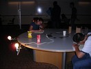 A small beaker sits on a table with a thermometer in it. A bright light shines on the beaker.