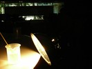 A small beaker sits on a table with a thermometer in it. A bright light shines on the beaker.