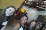 A blurry photo of three girls in a classroom.